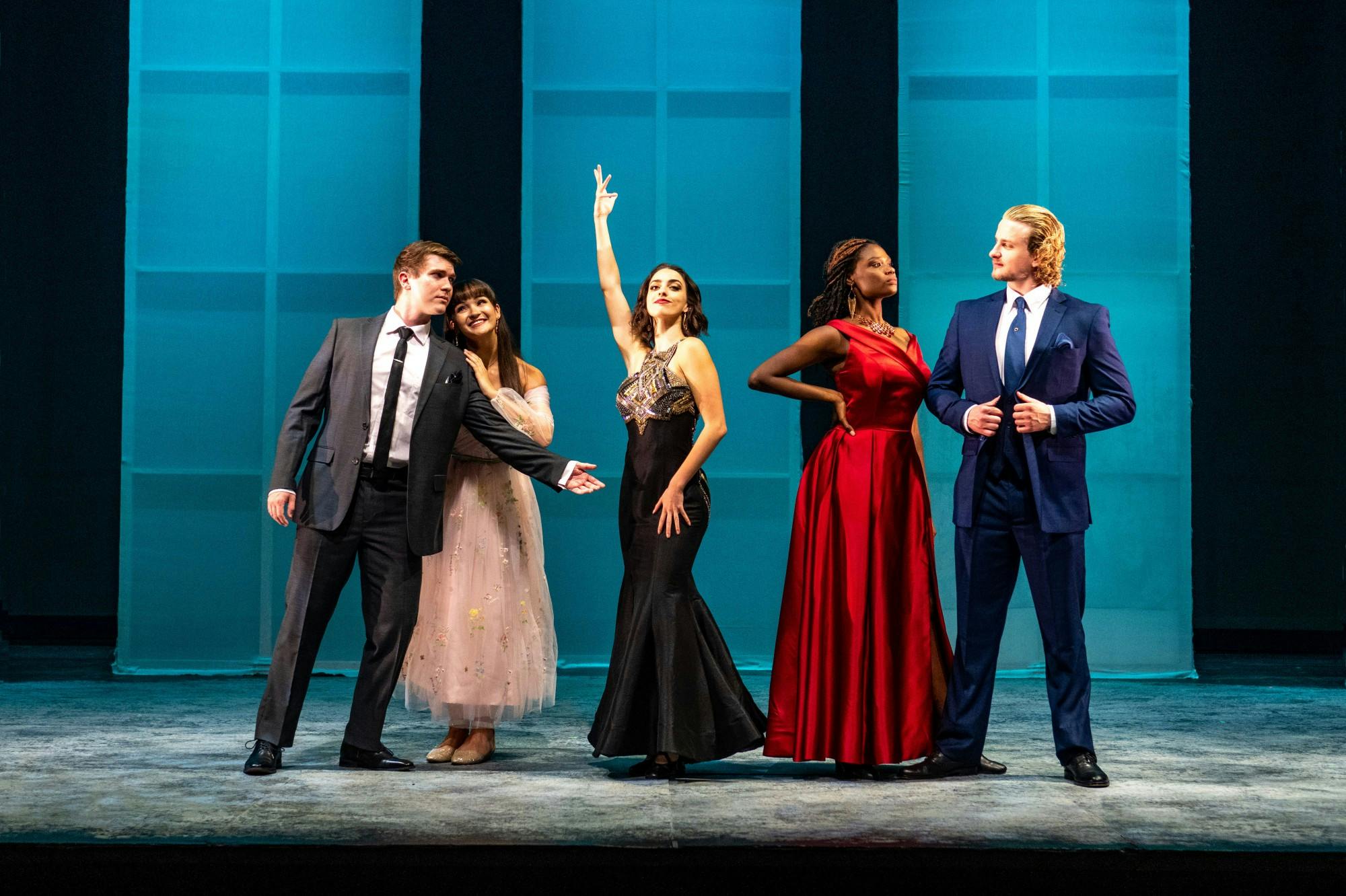 A group of 5 theater students posing dramatically on stage.