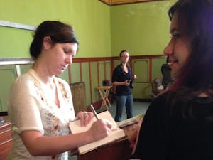 	Visiting author and 2001 Otterbein graduate Mindy McGinnis signs student copies of her debut novel, &#8220;Not a Drop to Drink.&#8221;