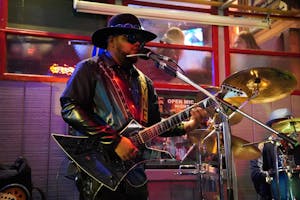 A man playing guitar and singing on stage 