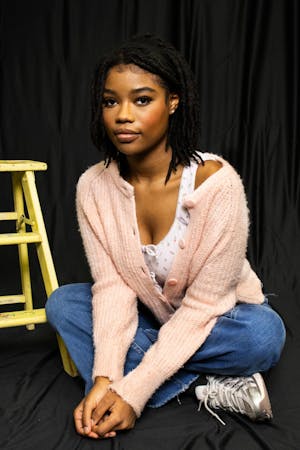 Student posing for a photo in a squat position.