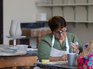 Otterbein post-bachelor student, Isabel Alvarez, working on a ceramic combination of a human and parrot.