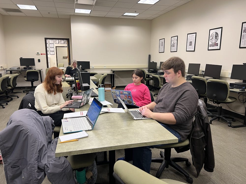 <p>The T&amp;C staff (from left to right: Promotions Manager Sophia Imundo, Staff Adviser Dr. Hillary Warren, Opinion Reporter Abby Vitali, and Copy Supervisor Hayden Garrett) work on their newest assignments in the T&amp;C lab.</p>
