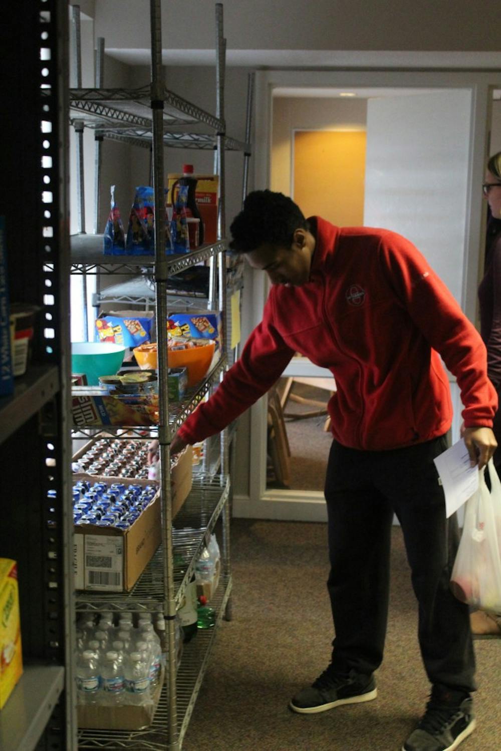 <p>Erick Martinez, a peer advocate at Promise House, packs a bag of groceries to use in his residence hall&nbsp;throughout the week.</p>