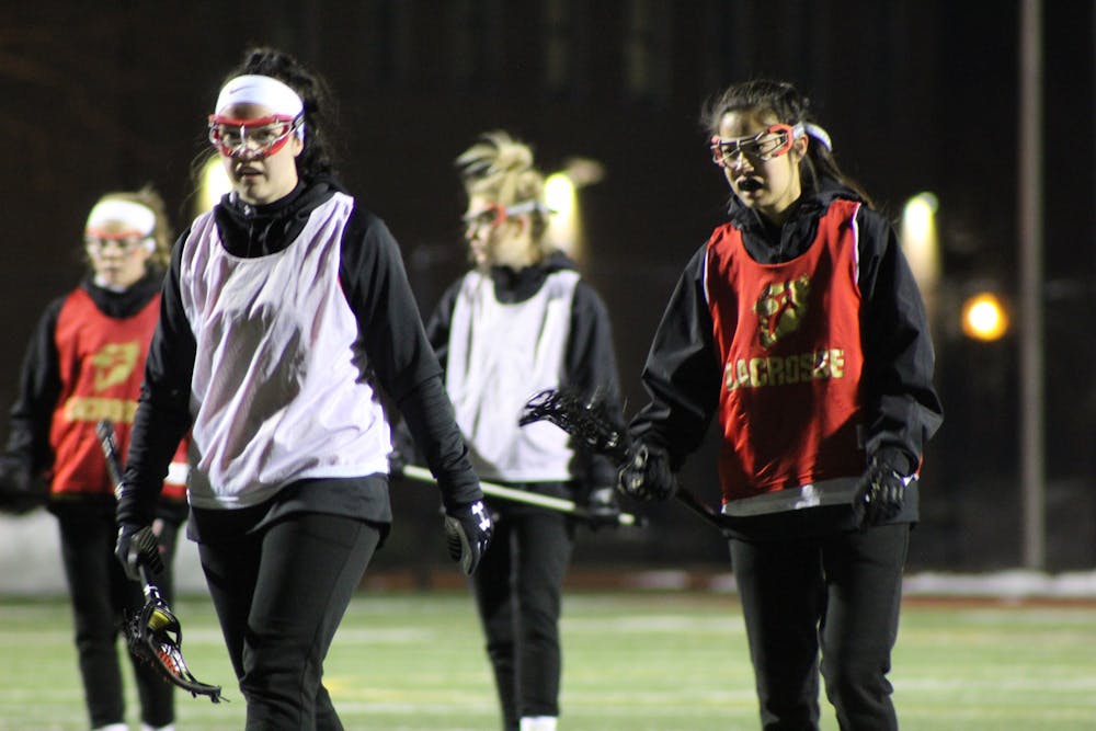 <p>Lexie Van Cleef (left) and Abby Chappell (right) during a women's lacrosse practice on Feb. 17.</p>