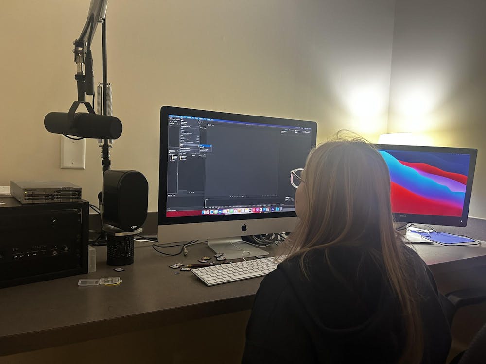 Staged photo of a person sitting in the editing booth 