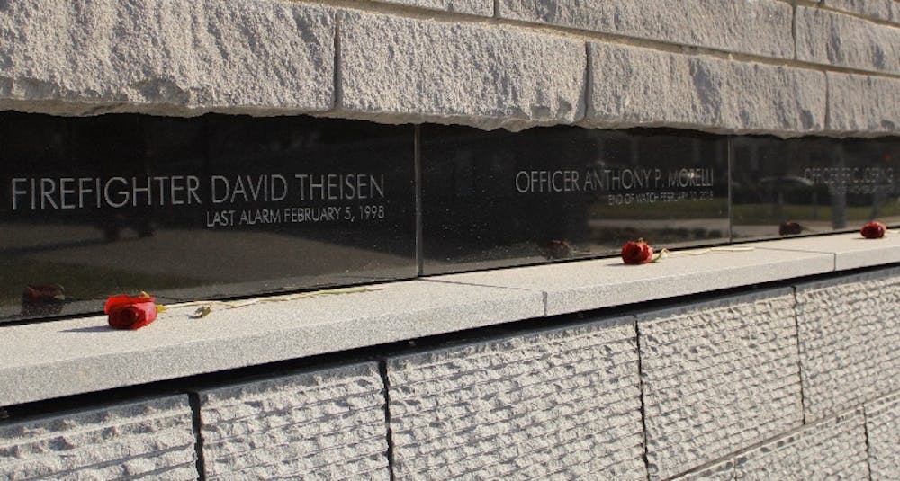 The names of firefighter David Theisen and Officers Anthony Morelli and Eric Joering are engraved in the new stone memorial wall above a water feature.