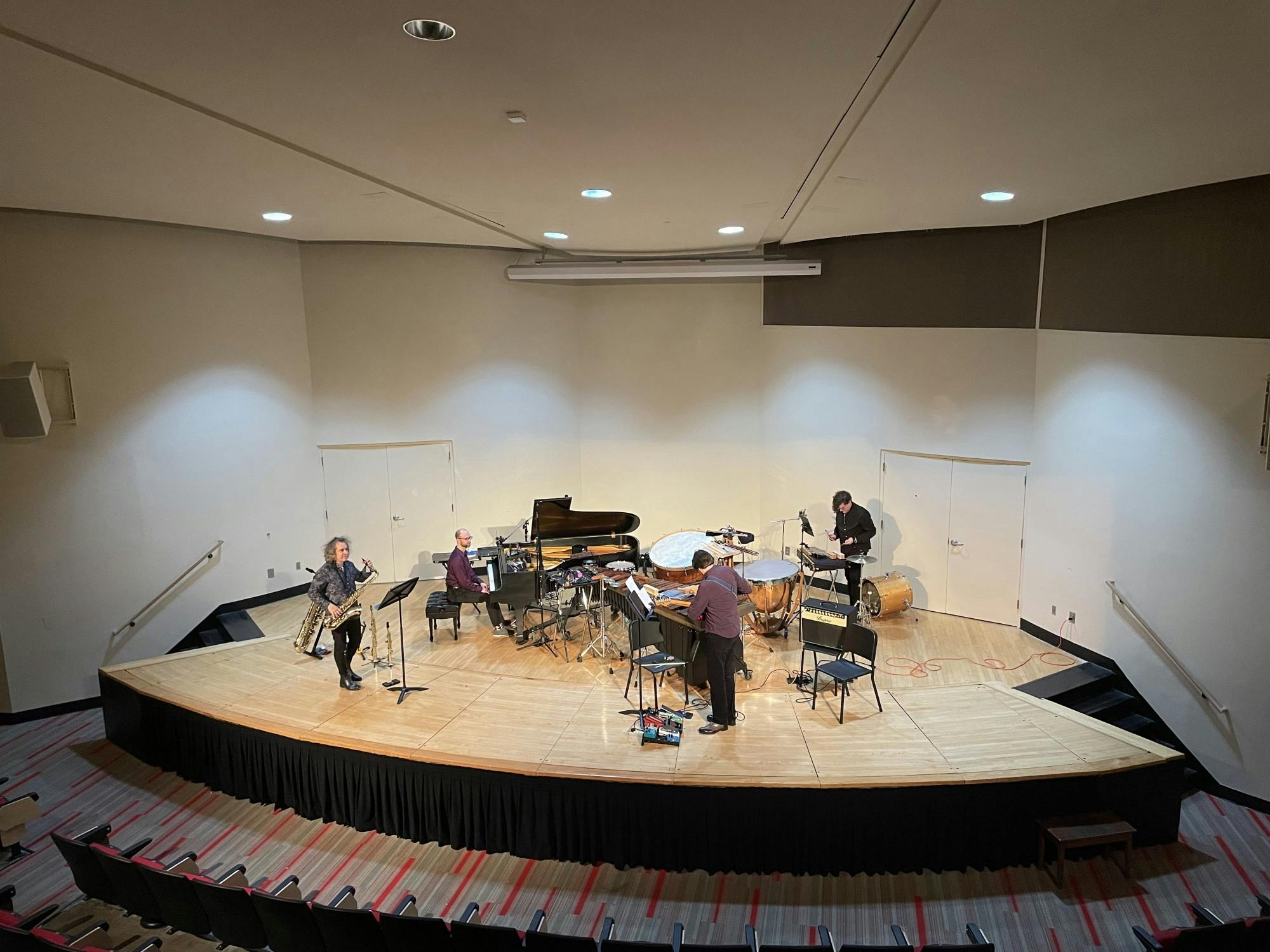 The four members of The Hinge Ensemble play the piano, saxophone, percussion, and electric guitar.