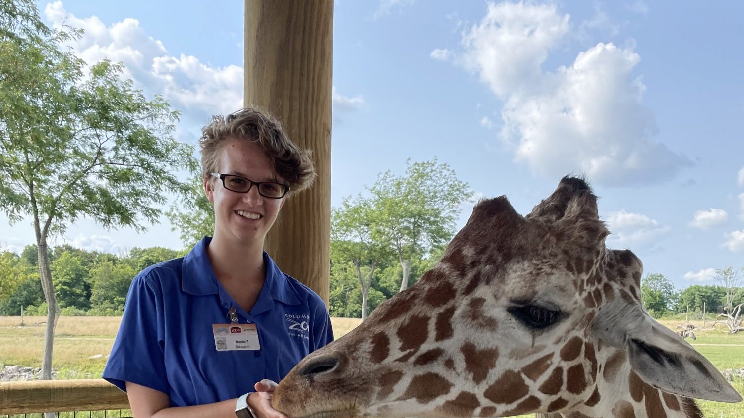 Maddie Torbert, a junior double majoring in Zoo & Conservation Science and Biology at Otterbein, feeds a giraffe while working at the Columbus Zoo this past summer. The Columbus zoo lost its AZA accreditation in December 2021, but plans to reapply in five