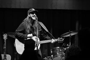 Black and white image of a man performing on stage at Skully’s Music Diner. Photo taken by Angelina Godfrey