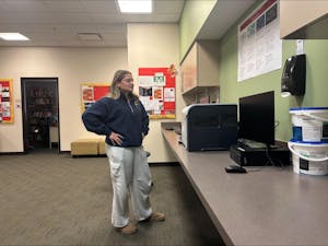 A woman with her hands on her hips stares at a printer