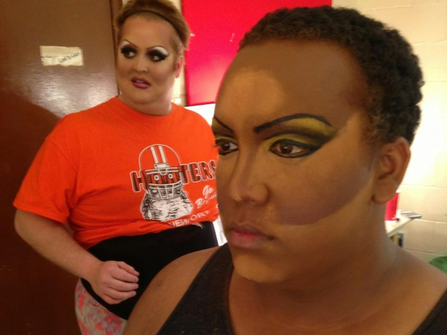 	Anthony Murphy, right, who performs as Shelita Buffet in the drag queen show, checks his makeup in the mirror. 