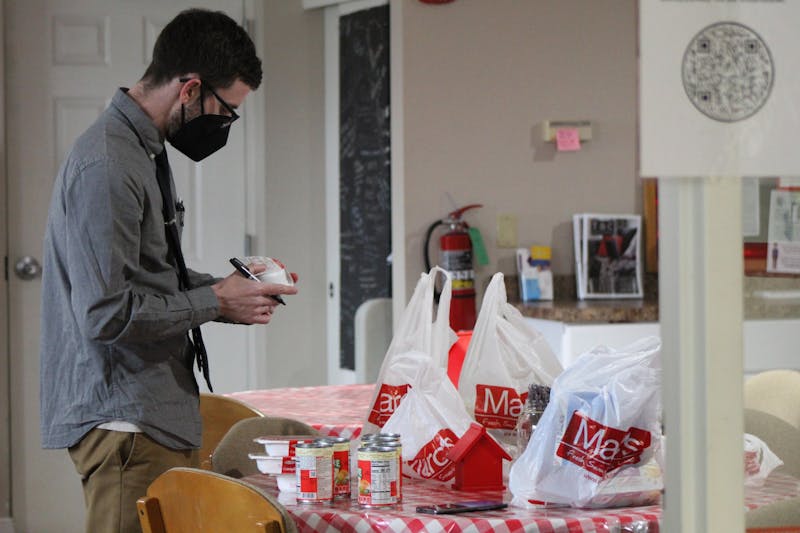 Wesley Engel, Resource Manager at the Promise House, takes stock of the inventory and checks expiration dates.
