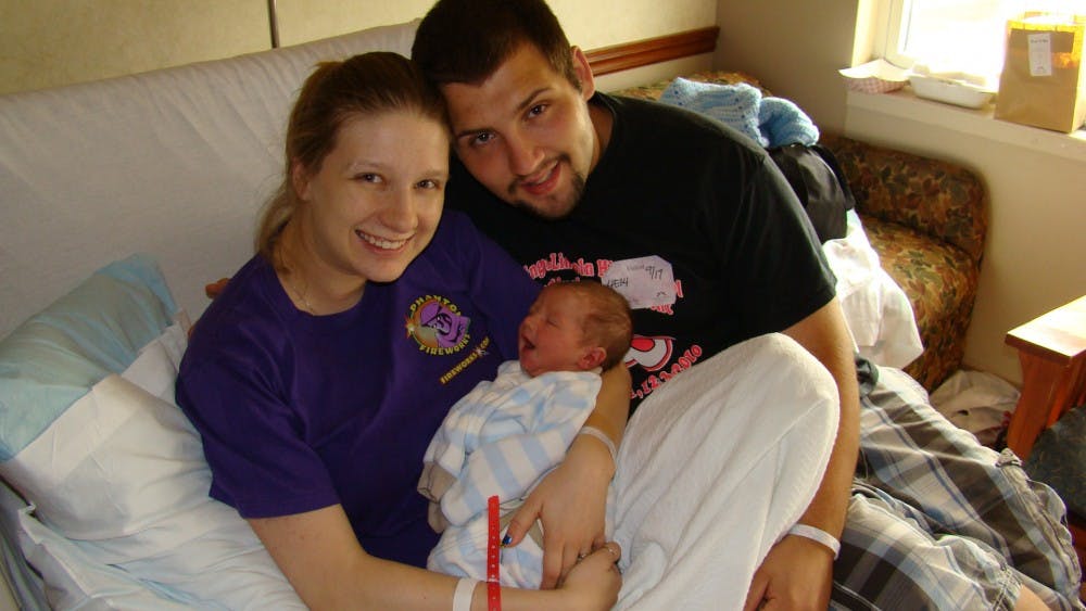 	<p>Patience and Ben Cooper and their new baby, Gabe. The couple caused a campus stir in the spring when they impromtu-ly said their nuptials in the Zeta Phi fraternity house.</p>
