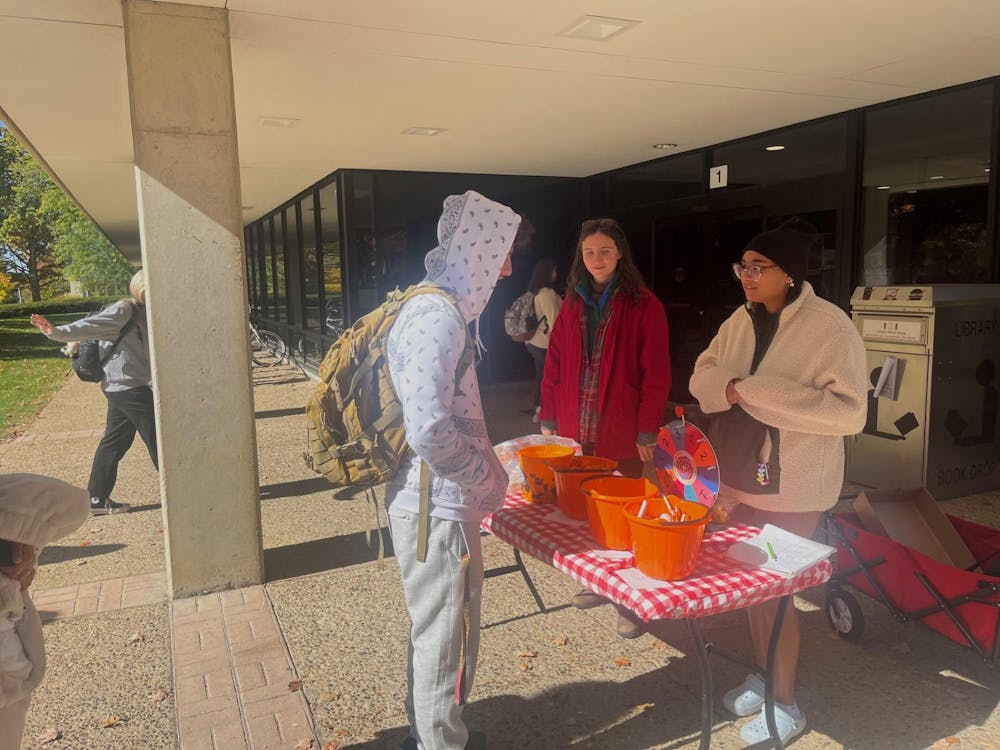<p>Promise House volunteers hand out snacks for students outside of Courtright Memorial Library.</p>