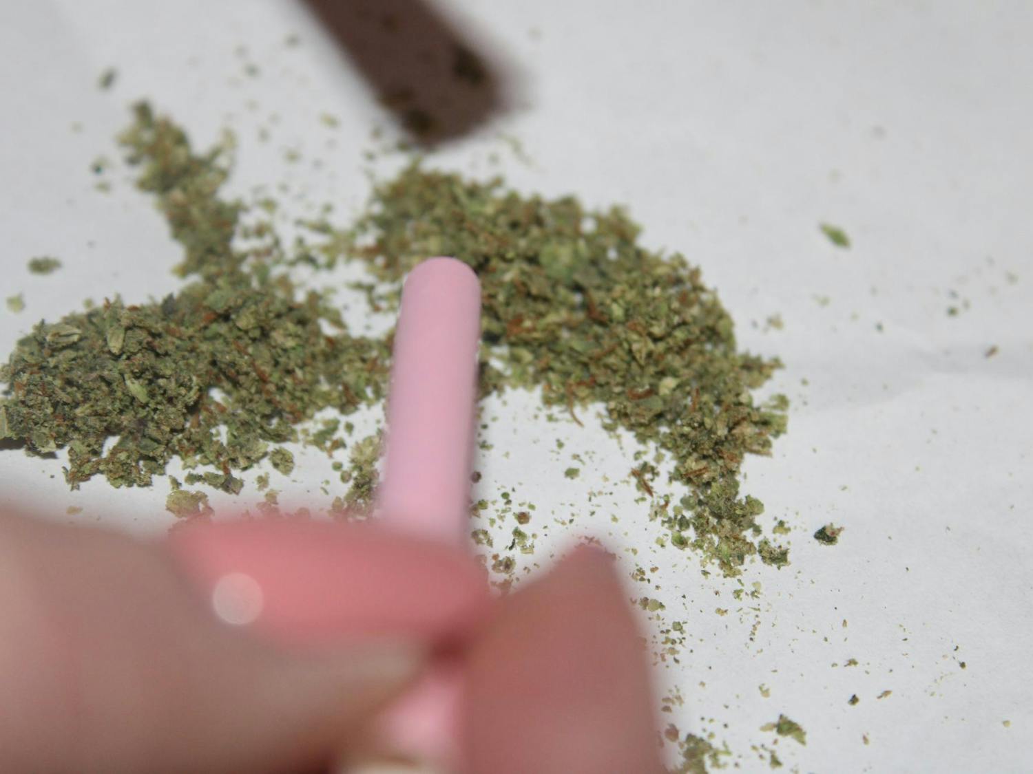 Marijuana being packed into a joint on an ashtray.