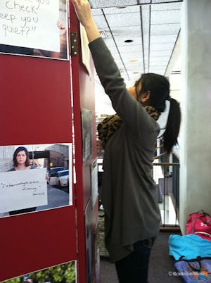 Chivy Chattana, a sophomore pre-med major, helps set up Project Unbreakable’s exhibit, one of the events during One Billion Rising.
