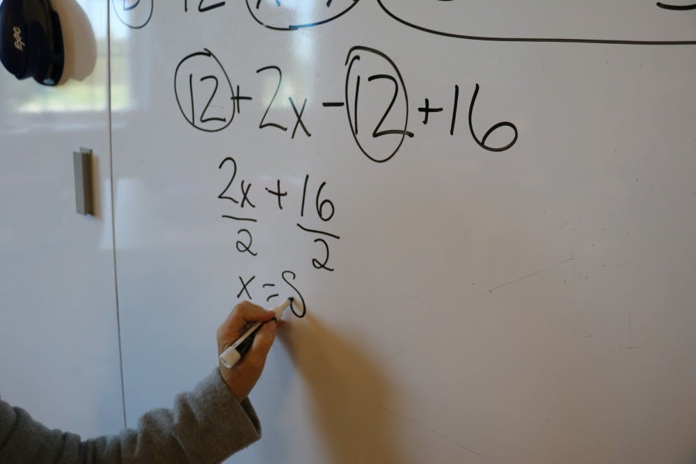 Sandy Light solves a math problem in her classroom