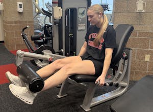 Girl with blonde hair doing seated leg extensions.