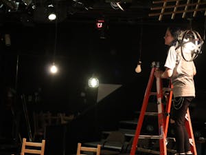 A theater student adjusts the lighting for the department production of "Our Town," which opens Feb. 9 in the Campus Center Pit Theater.