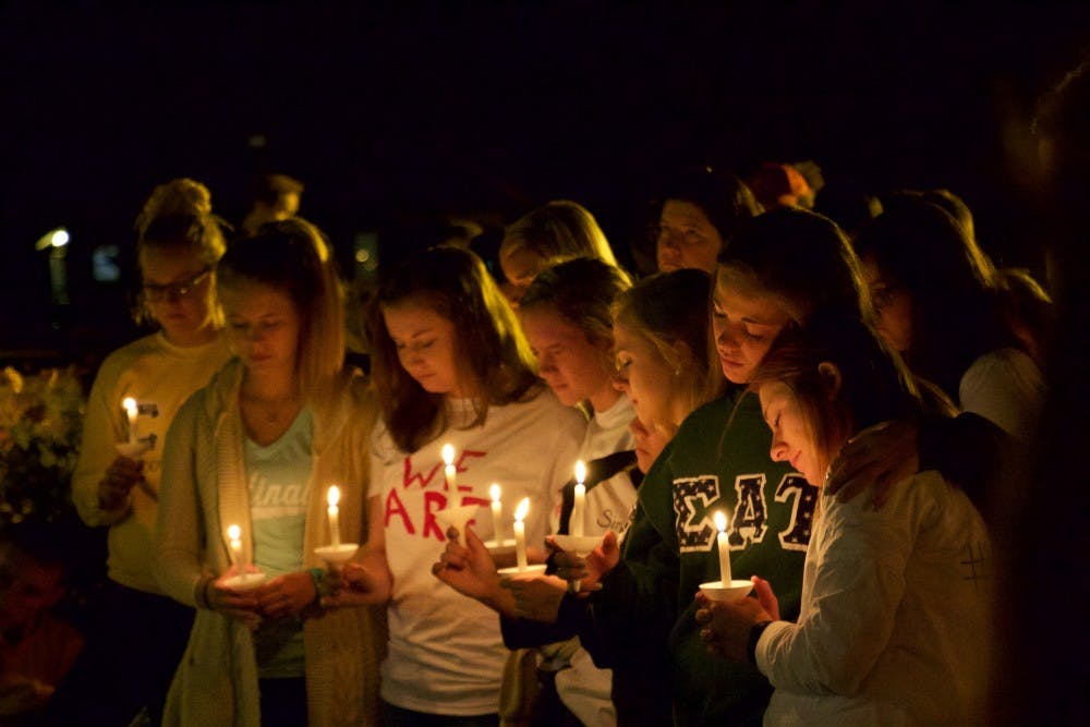 <p>Students attend vigil for fellow student Anna Phillips, illuminated by candlelight.</p>