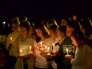 Students attend vigil for fellow student Anna Phillips, illuminated by candlelight.