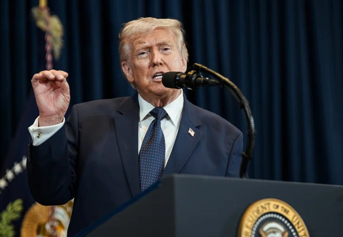Donald Trump on a podium speaking into a microphone.