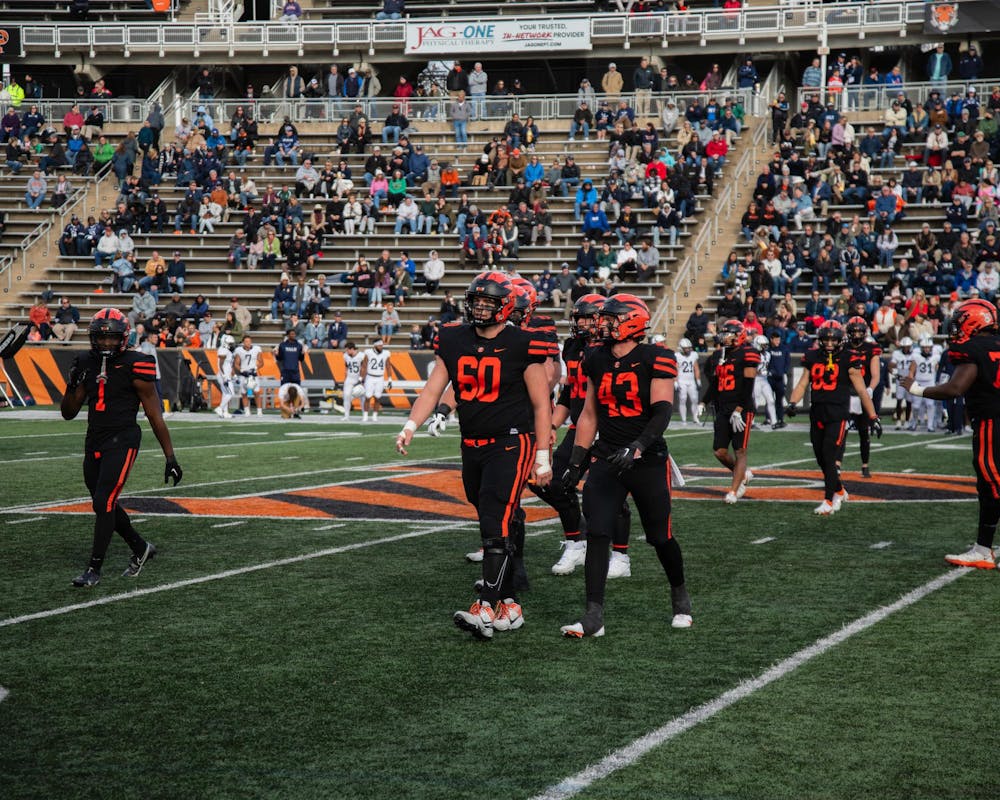 Group of men in black jerseys on football field.