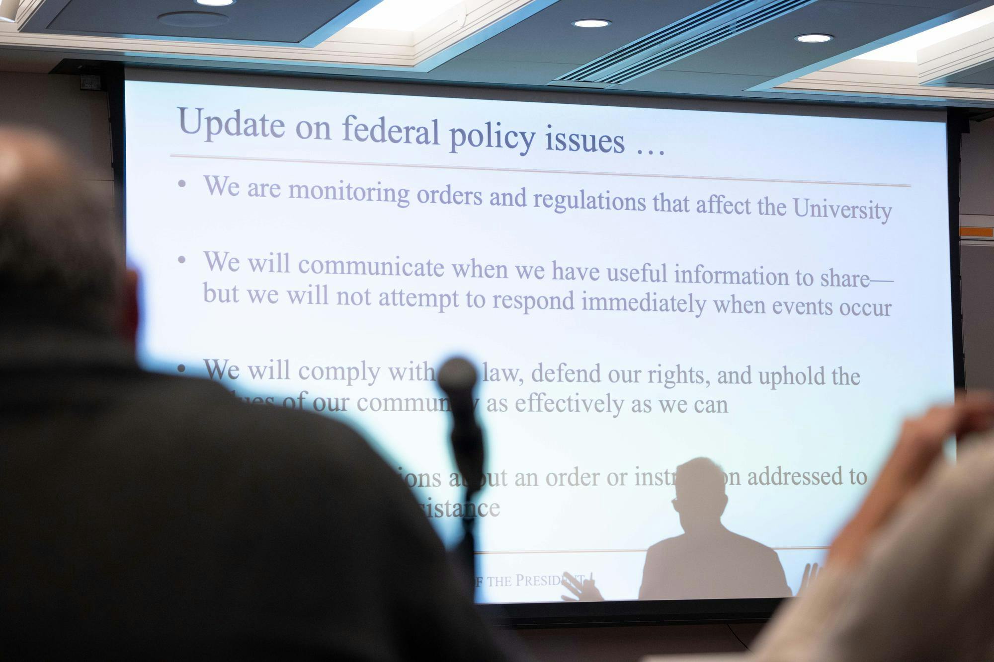 A shadow of a man falls on a screen reading "Updates on federal policy issues"