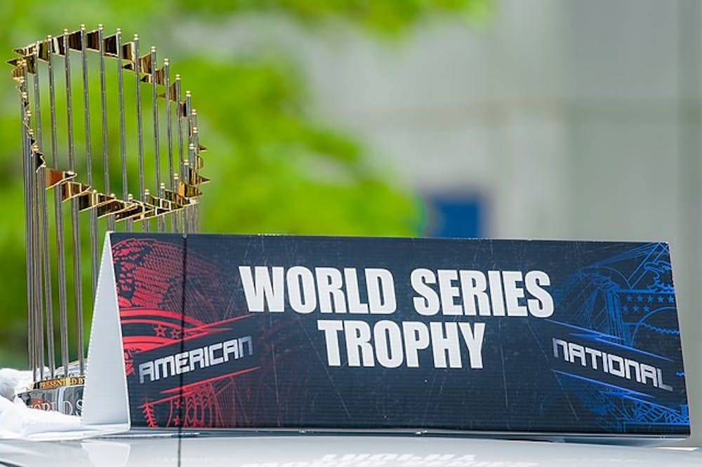 The Commissioner's Trophy of gold and silver sits behind a black, red, and blue sign that reads, 'World Series Trophy.'