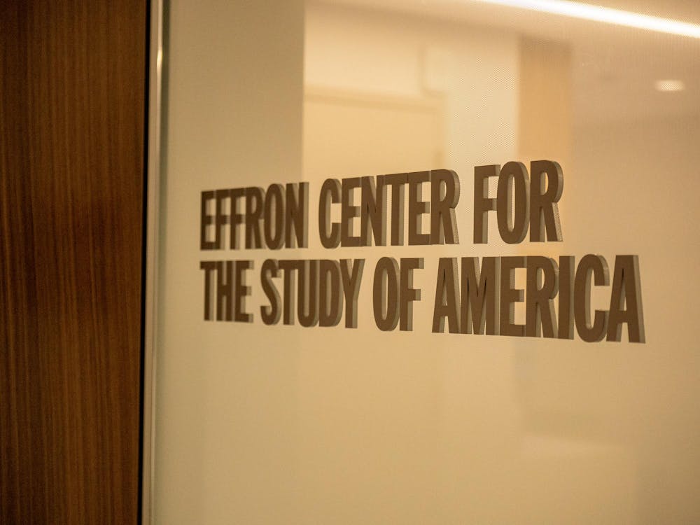 On the left, brown woodgrain. On the right, a gray glassy surface with text overtop reading: "EFFRON CENTER FOR THE STUDY OF AMERICA"