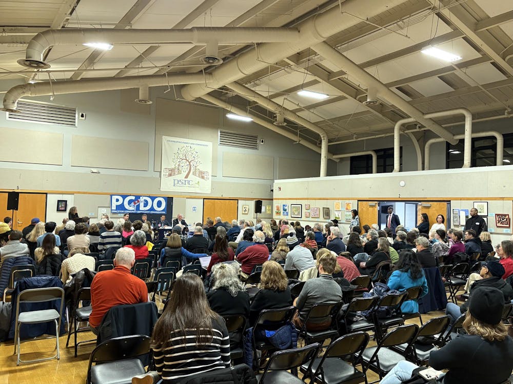 A room of people are gathered, aimed at a stage with candidates. 