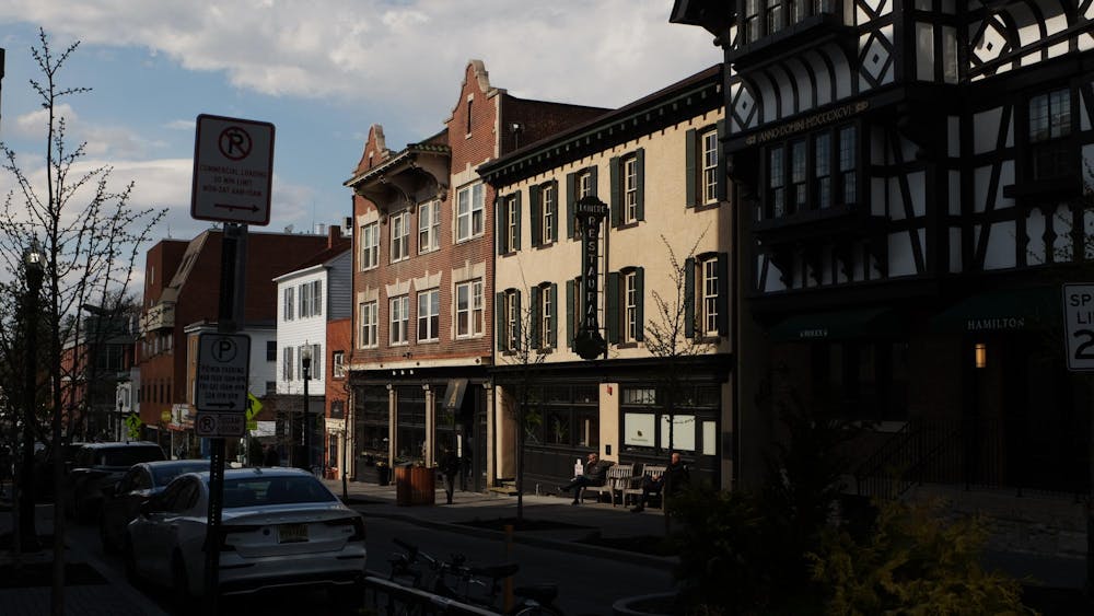 A dark street with a few buildings in the light