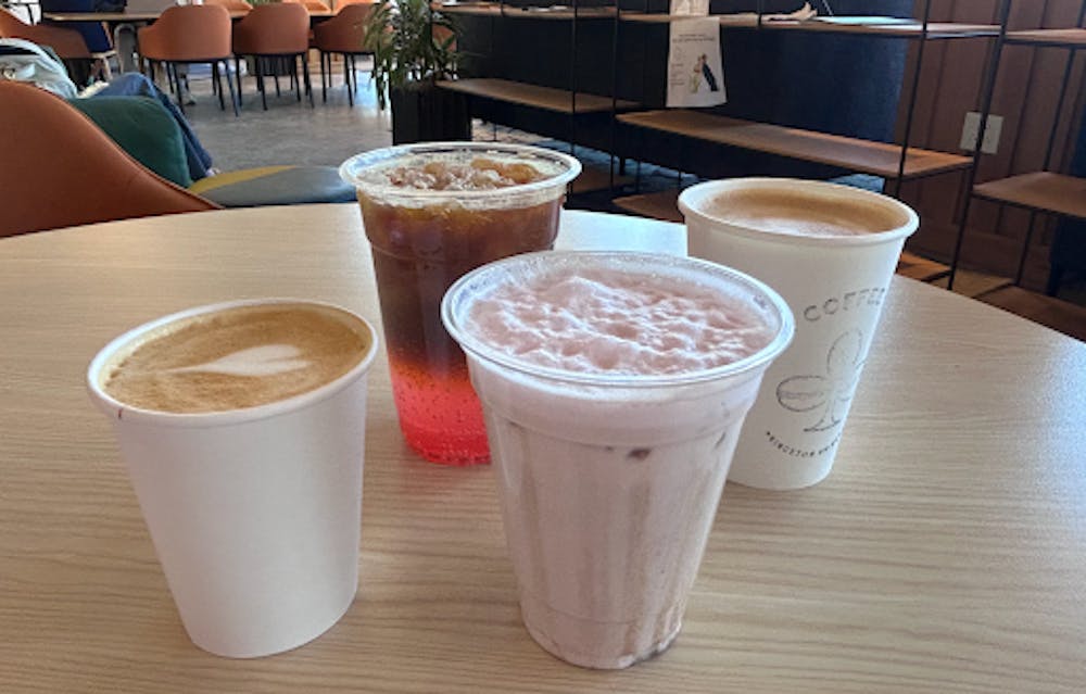 Four drinks placed on small round table at NCW Coffee Club.