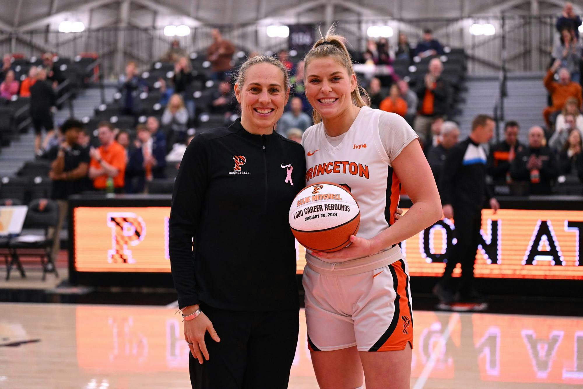 Ellie Mitchell holds white ball in front of Princeton crowd.