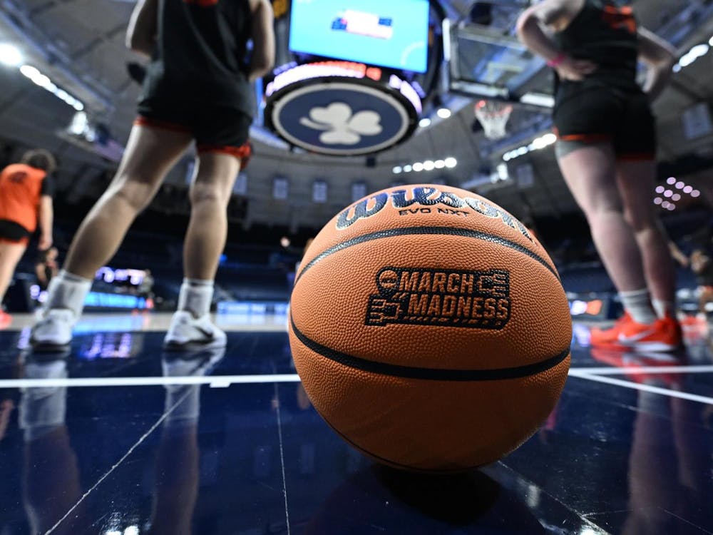 Basketball in foreground and women in background.