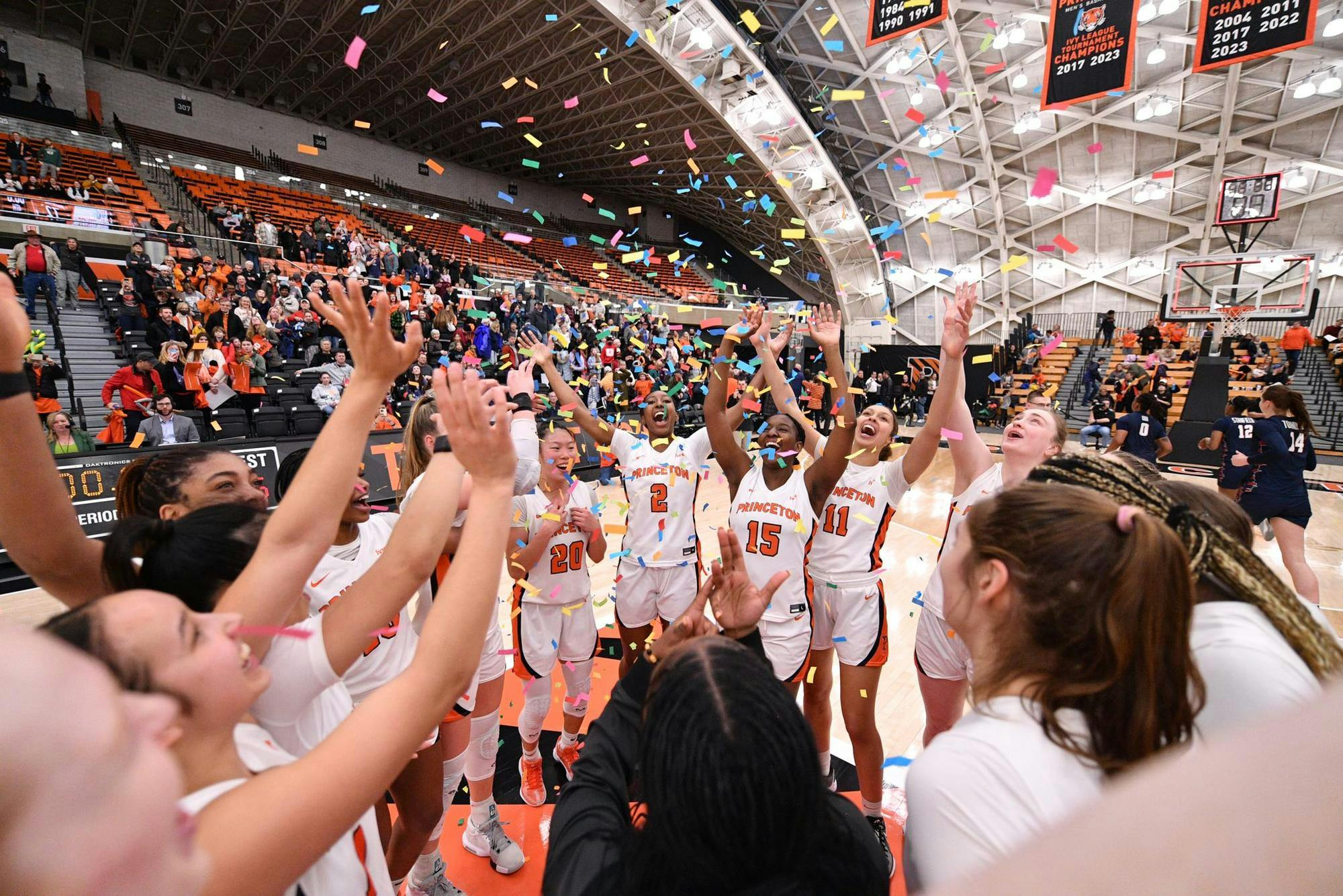 A group of female basketball players celebrating with confetti raining down.