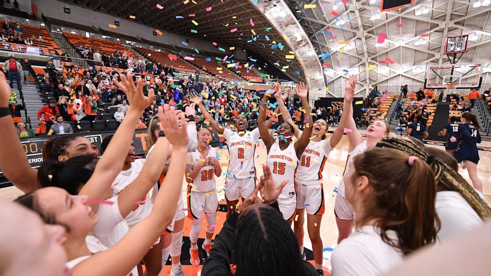 A group of female basketball players celebrating with confetti raining down.
