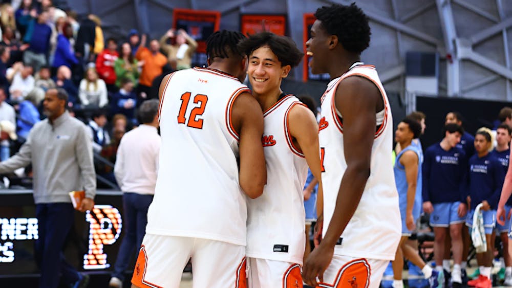 Player in white and orange basketball jersey embraces teammate 