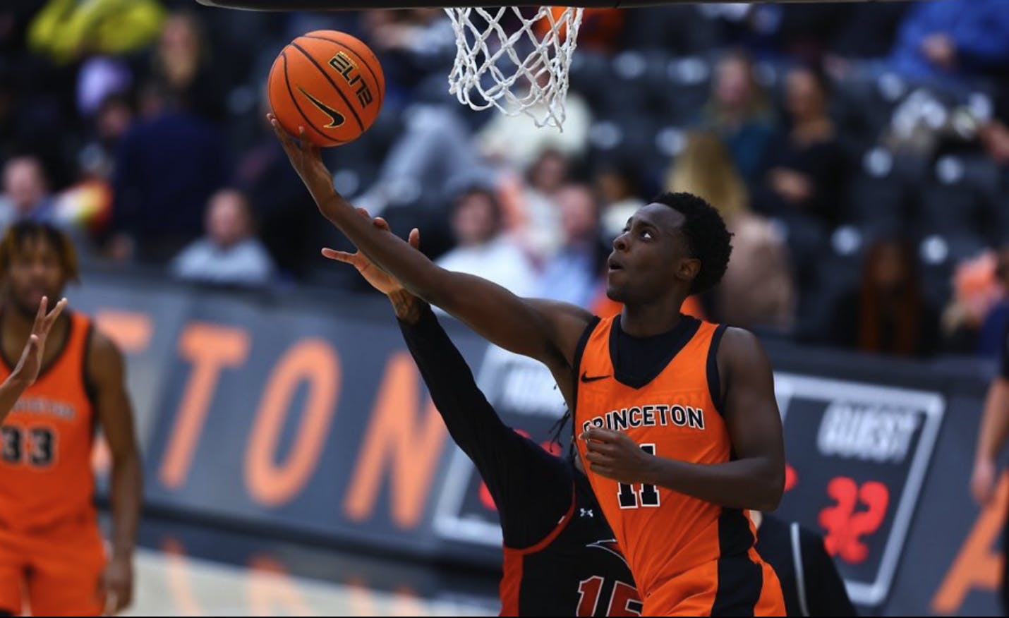 Princeton Guard Darius Gakwasi shooting the ball on a finger roll underneath the basket.