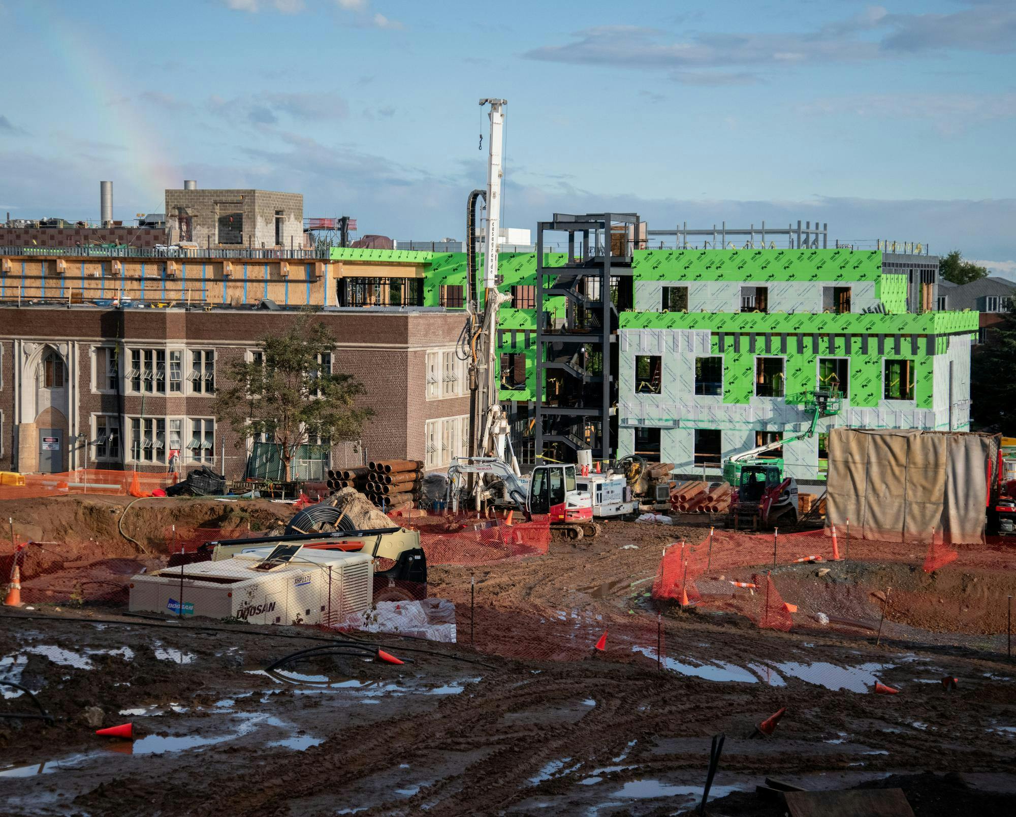 Construction on Hobson college is seen with a rainbow in the corner.