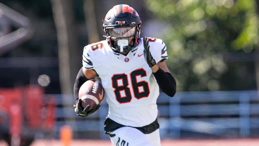 A man in uniform with a football running towards the camera