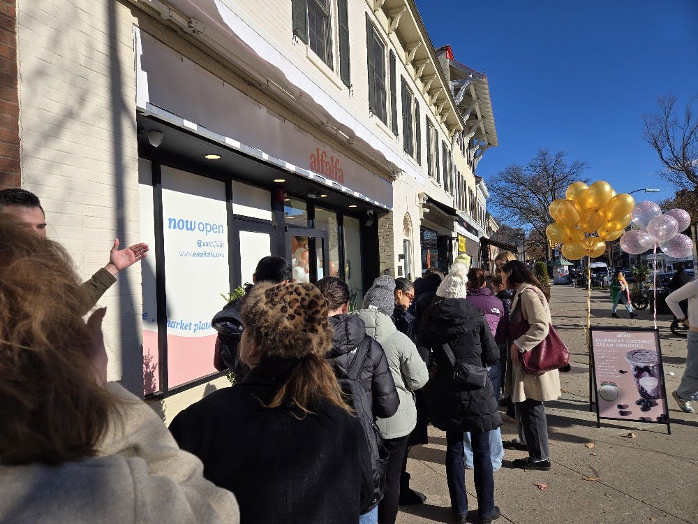 Line of people standing outside a restaurant. 