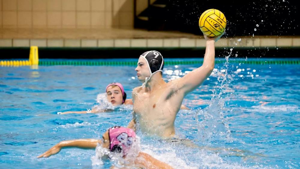 A men’s water polo player launching the ball.