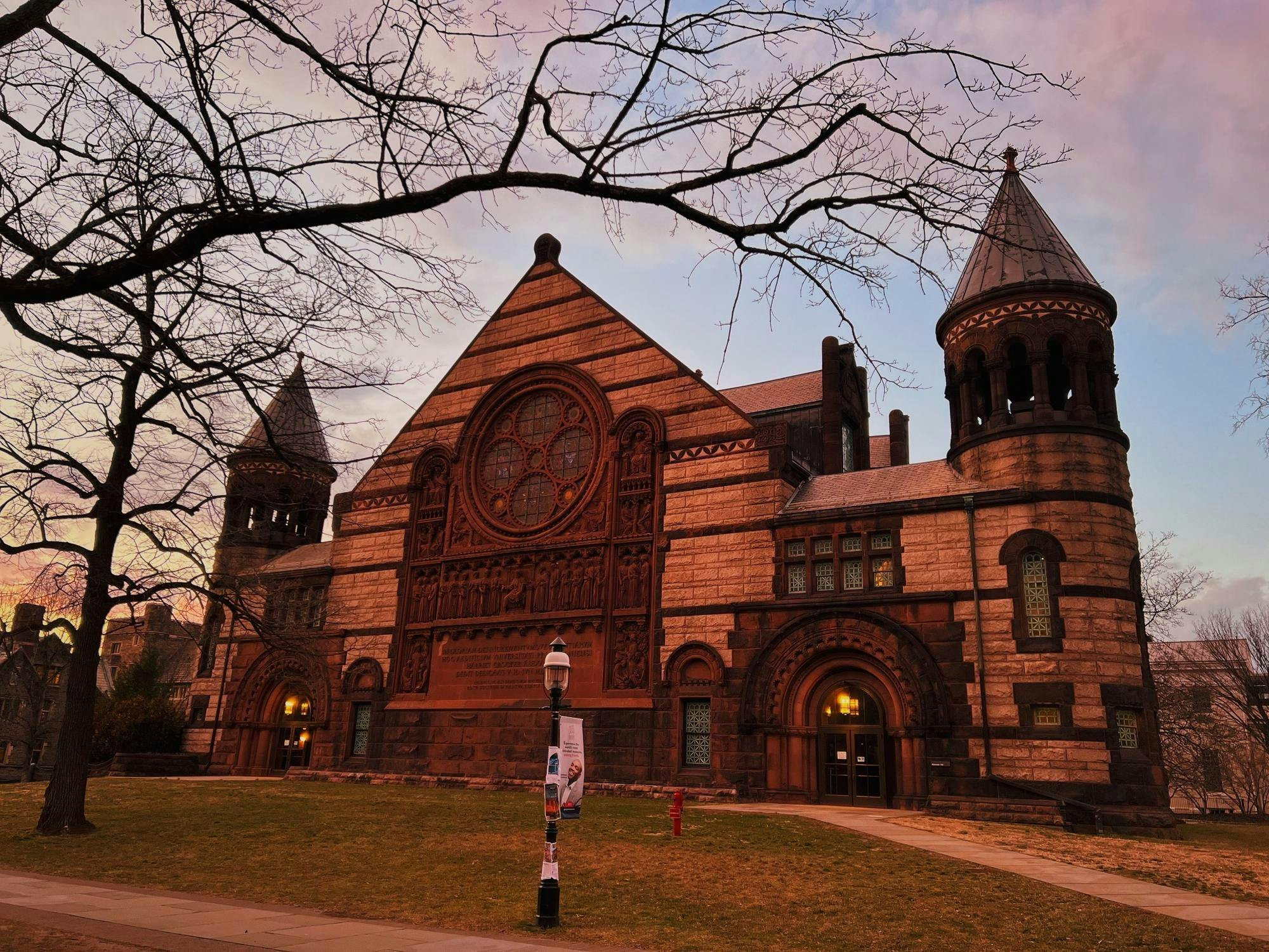 A large Gothic-style auditorium stands in the sunset.