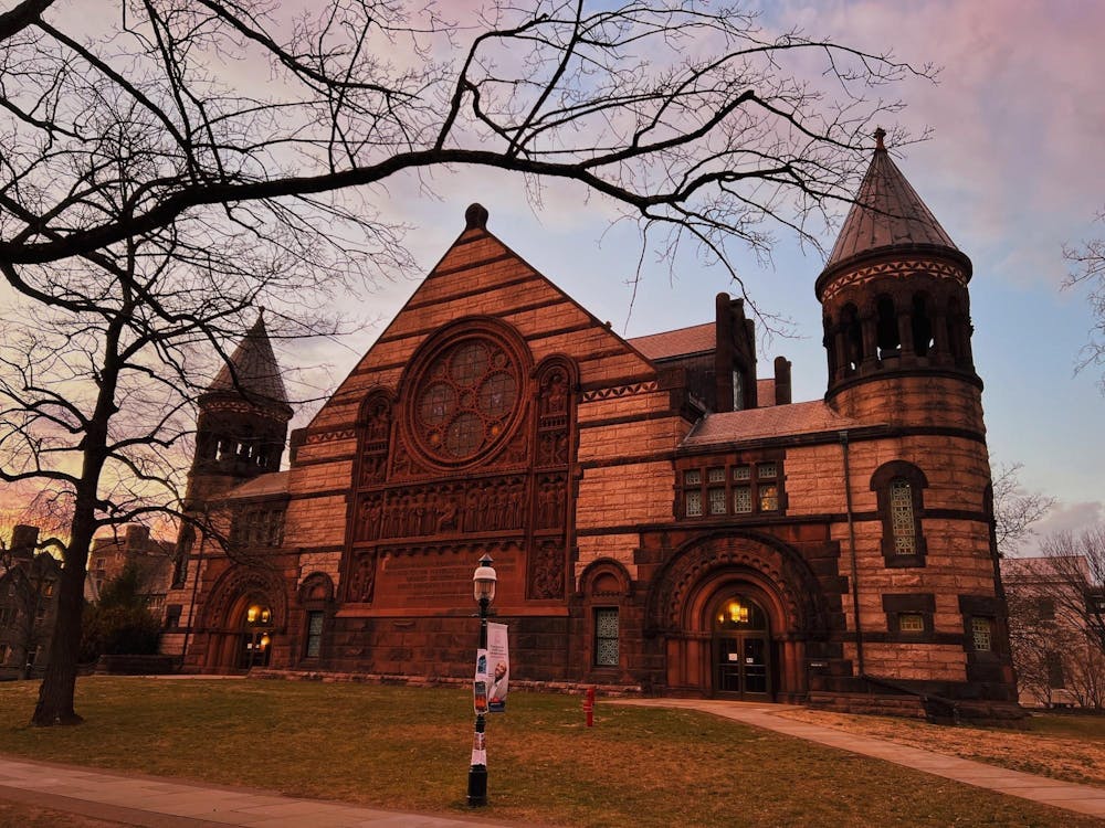A large Gothic-style auditorium stands in the sunset.