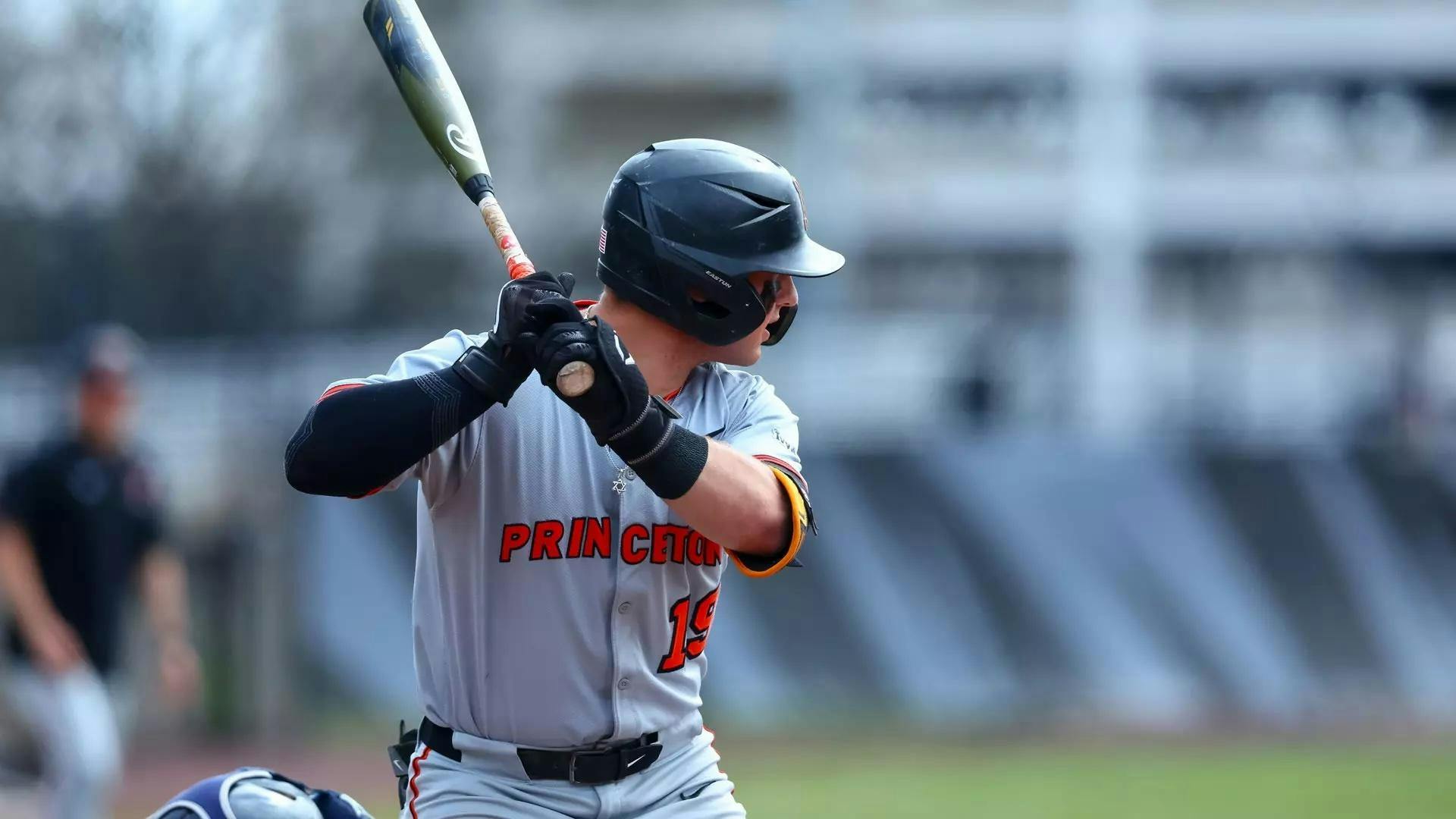 Man standing with baseball bat about to swing.
