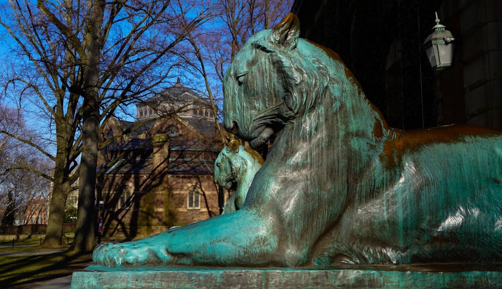 Two tiger statues covered in green patina.