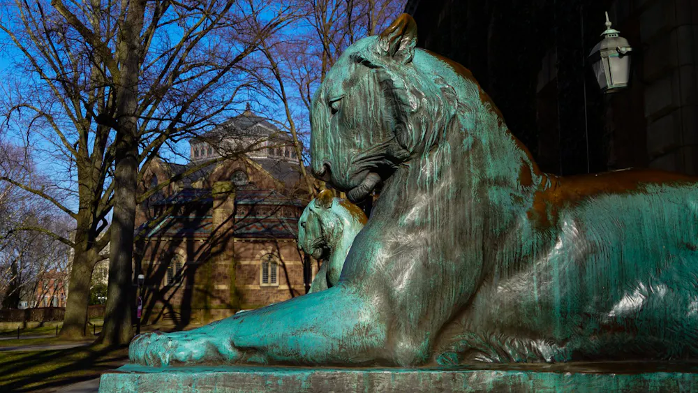 Two tiger statues covered in green patina.