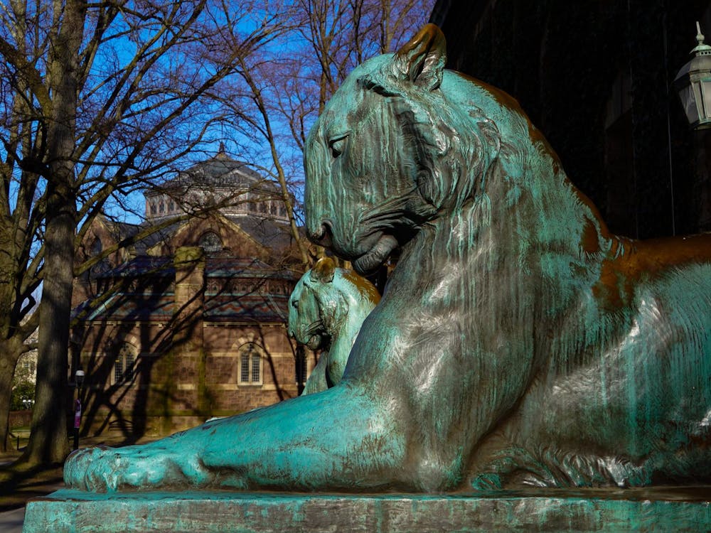 Two tiger statues covered in green patina.
