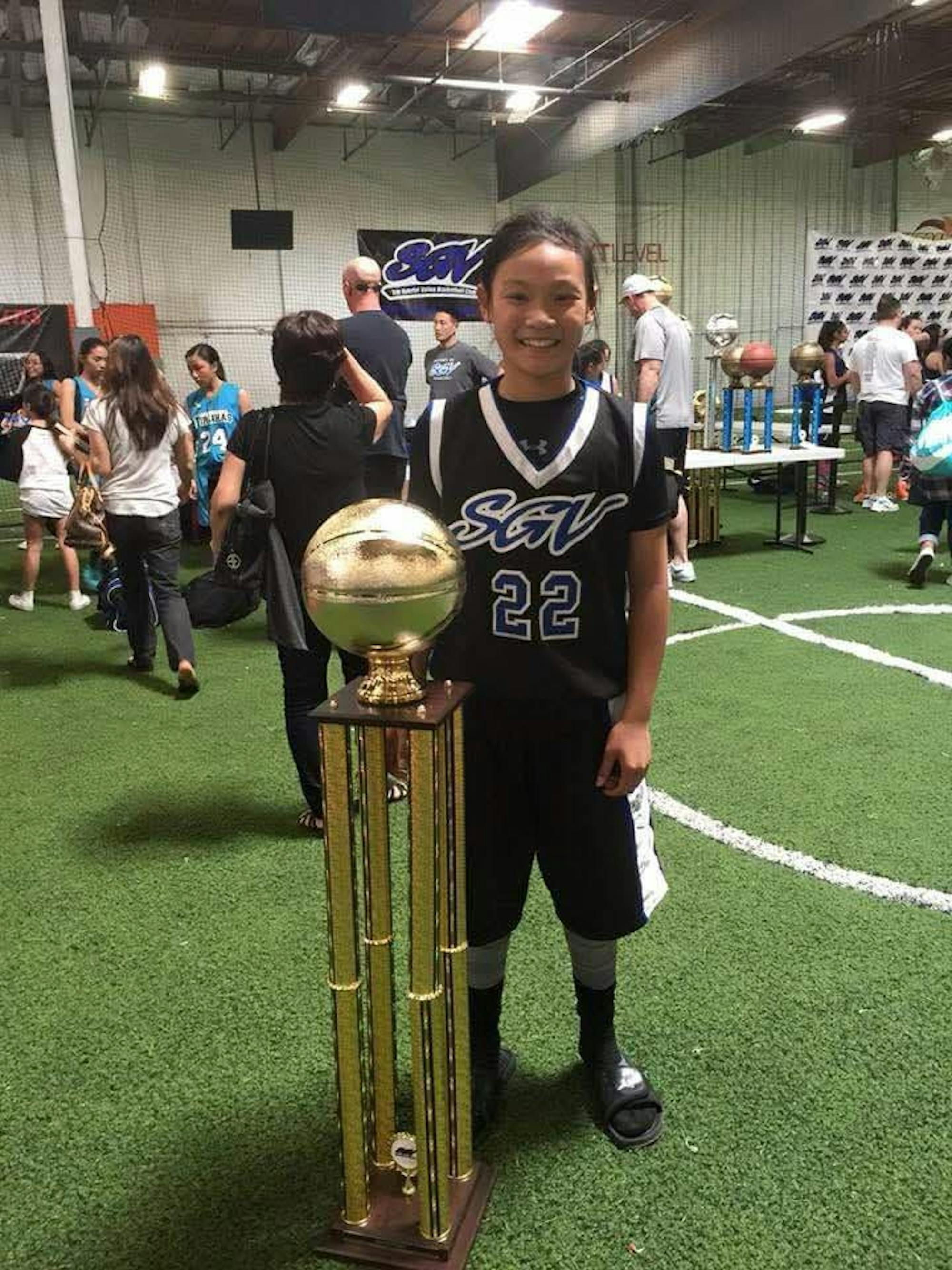 Girl standing with trophy.